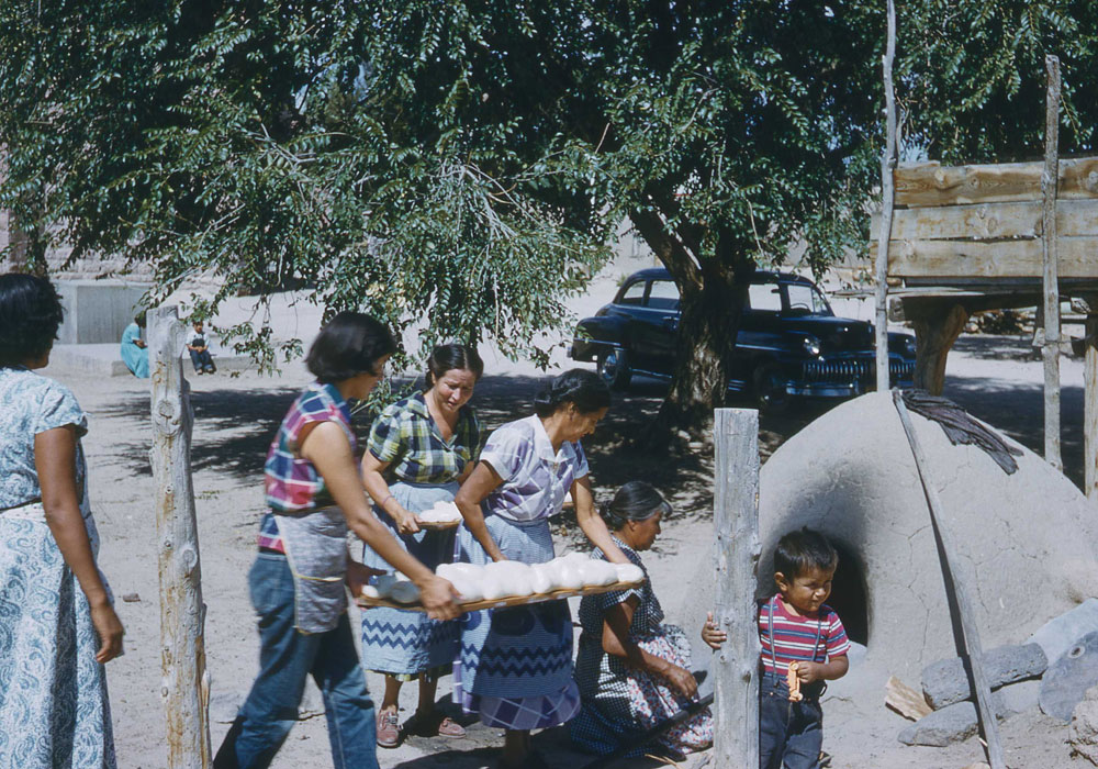 Women baking bread in a traditional oven in San Juan (now Ohkay Owingeh), NM (photo by Henry Tribe, 1958). Women baking bread in a traditional oven in San Juan (now Ohkay Owingeh), NM (photo by Henry Tribe, 1958).