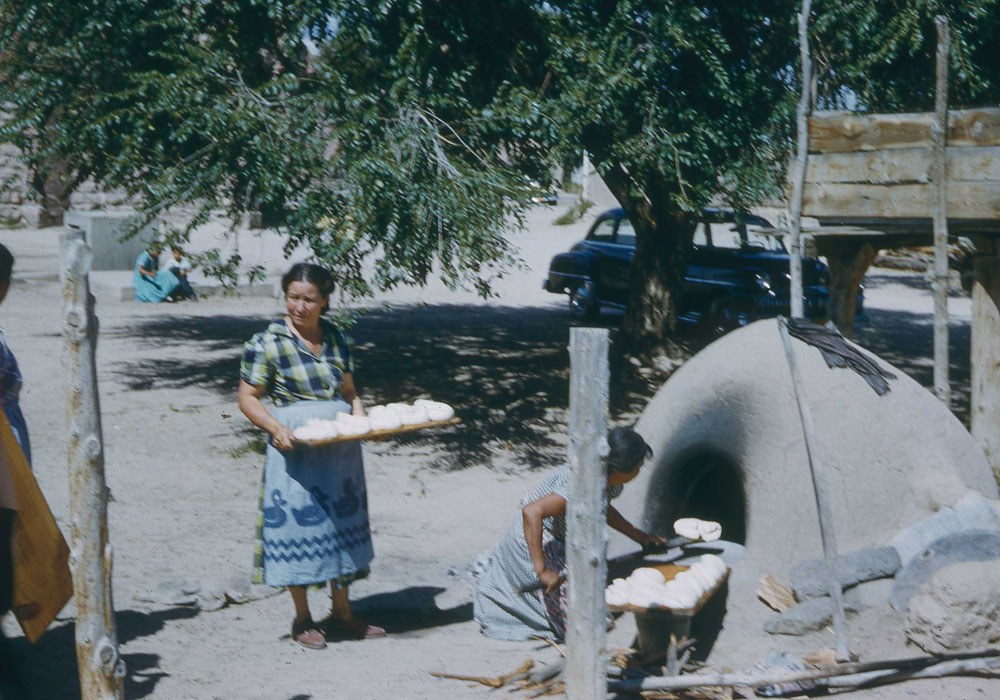Women baking bread in a traditional oven in San Juan (now Ohkay Owingeh), NM (photo by Henry Tribe, 1958). Women baking bread in a traditional oven in San Juan (now Ohkay Owingeh), NM (photo by Henry Tribe, 1958).