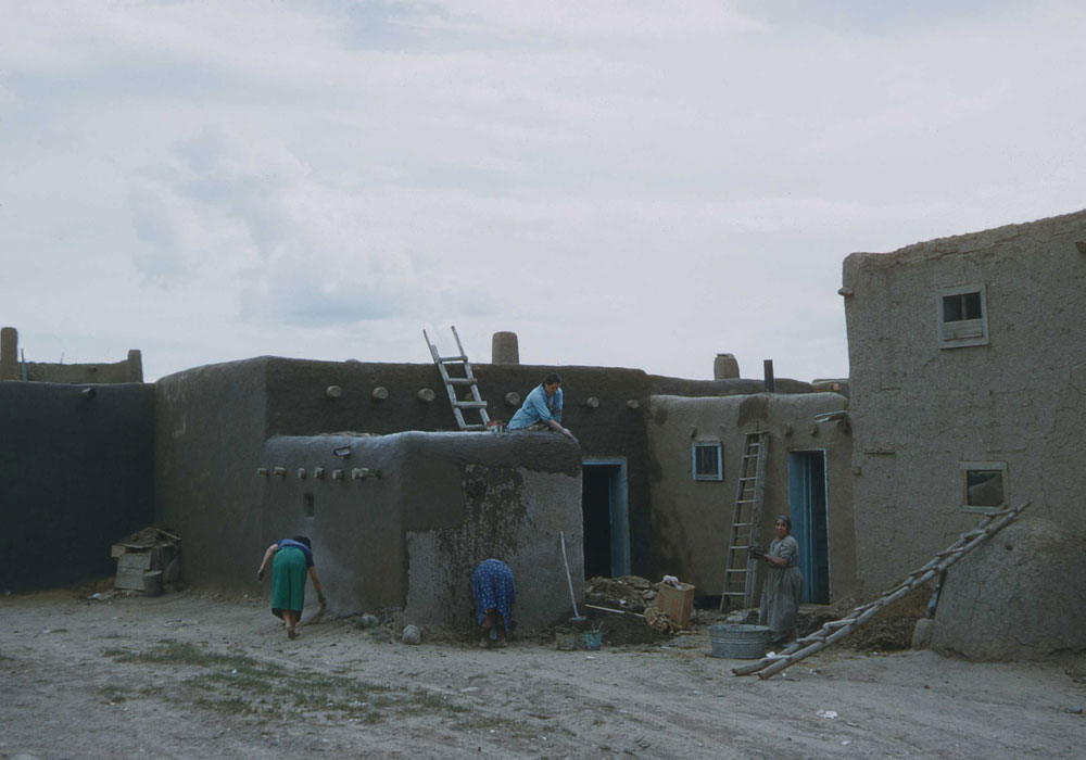 Taos Indian village - plastering walls (photo by Henry Tribe 1958). Taos Indian village - plastering walls (photo by Henry Tribe 1958).